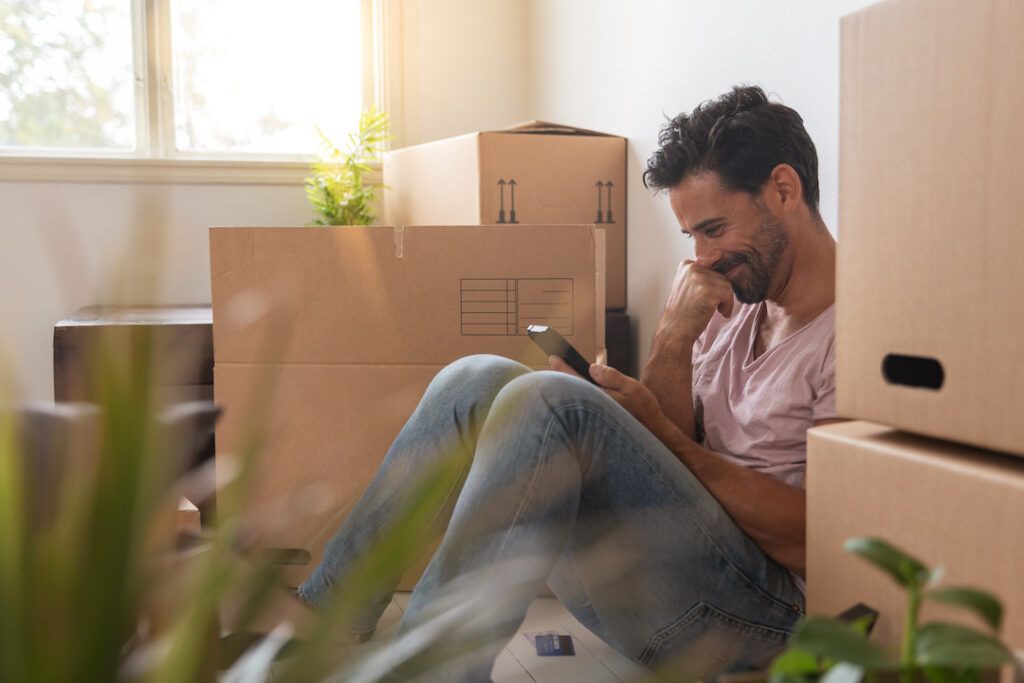 Man sitter mellan flyttlådor